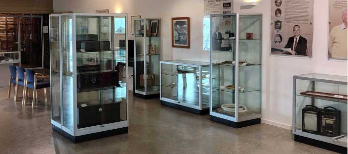 Interior of museum, glass cabinet display of old equipment.