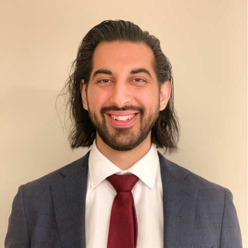 Saleem Ameen in a suit with a white shirt and red tie.